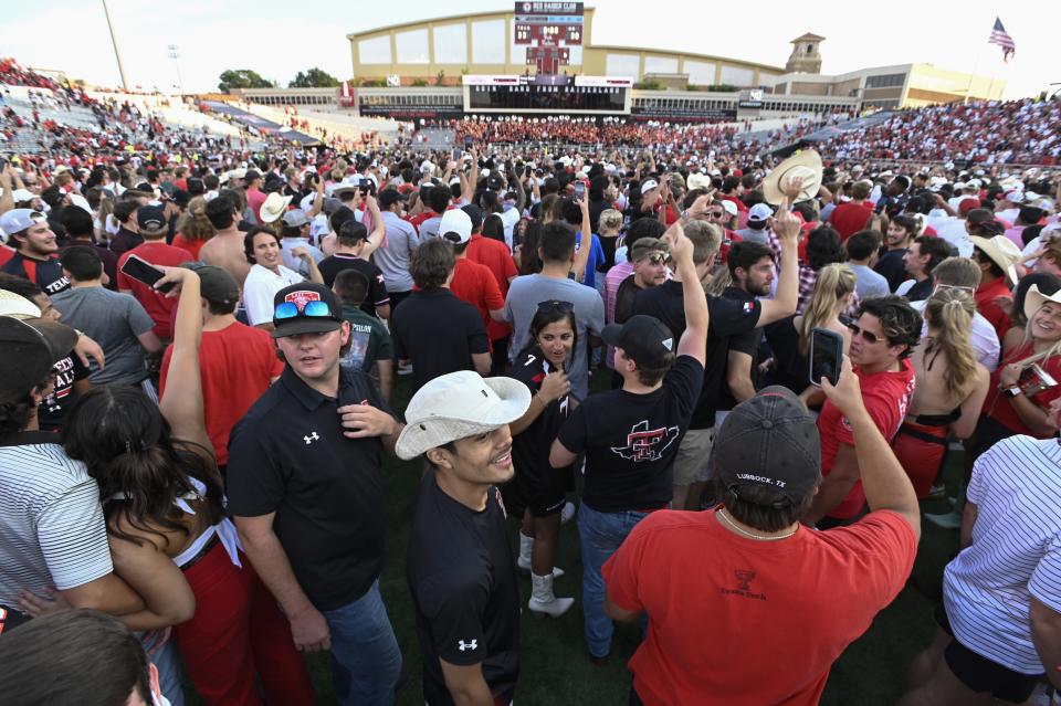 Texas Tech fans stand on the field after Texas Tech defeated Houston in overtime in an NCAA college football game Saturday, Sept. 10, 2022, in Lubbock, Texas. (AP Photo/Justin Rex)