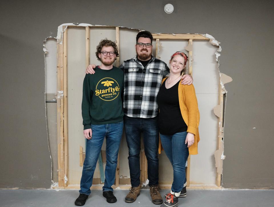 Starflyer Brewing Co. cofounders Ethan Comfort, from left) Andrew Archer and Bailey Archer stand in front of a wall that will be partially demolished to open the brewery to the Deli Ohio space in downtown Canton.