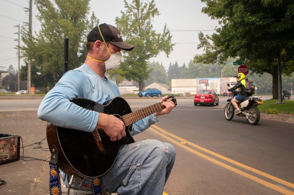 Milo William busks Tuesday amid poor air quality and high temperatures near the Ferry Street Bridge in Eugene.