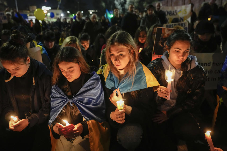 Numerosas personas que portan banderas de Ucrania y carteles contra la guerra participan en una procesión en una marcha en el distrito donde se ubica la embajada rusa en Roma, el viernes 24 de febrero de 2023, en el primer aniversario de la invasión rusa a Ucrania. (AP Foto/Alessandra Tarantino)