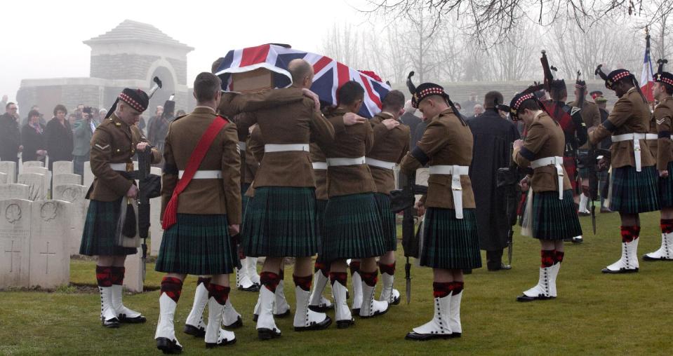 Members of a Scottish Division Firing Party hold their rifles inverted, in a sign of respect, as pallbearers carry the casket of British World War One soldier William McAleer during a reburial service at the Loos British World War One cemetery in Loos-en-Gohelle, France on Friday, March 14, 2014. Private William McAleer, of the 7th Battalion, Royal Scots Fusiliers, was killed in action on Sept. 26, 1915 during the Battle of Loos. His body was found and identified in 2010 during routine construction in the area and is being reburied with full military honors along with 19 unknown soldiers. (AP Photo/Virginia Mayo)