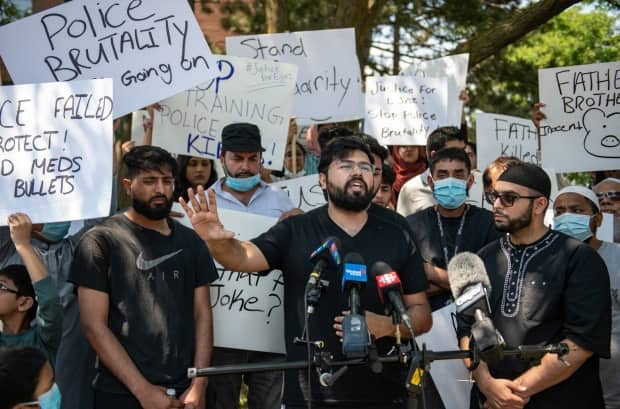 Hashim Choudhary, Choudry's nephew, addresses reporters in front of the apartment building where the fatal shooting occurred the night before. 