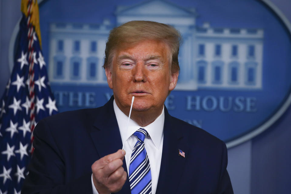 President Donald Trump holds up swabs as he speaks at the daily coronavirus briefing at the White House on April 19. (Photo: Tasos Katopodis via Getty Images)