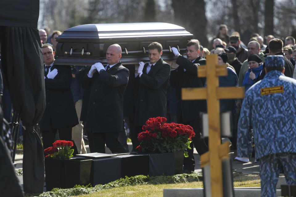 Cemetery workers carry a coffin with the body of slain Russian military blogger Vladlen Tatarsky, during a funeral ceremony at the Troyekurovskoye cemetery in Moscow, Russia, Saturday, April 8, 2023. Tatarsky, known by his pen name of Maxim Fomin, was killed on Sunday, April 2, as he led a discussion at a riverside cafe in the historic heart of St. Petersburg, Russia's second-largest city. (Anton Velikzhanin, M24/Moscow News Agency via AP)