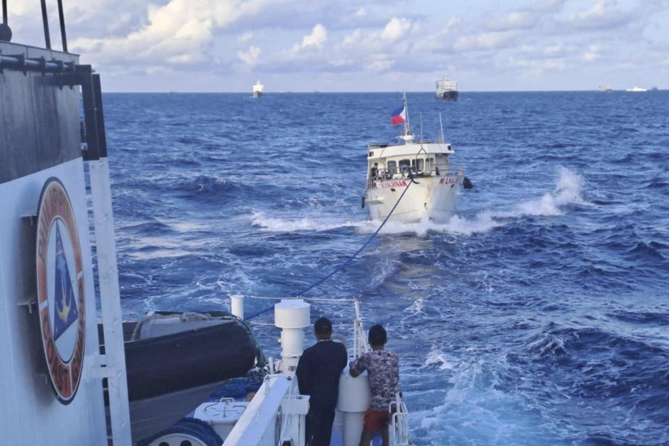 In this handout photo provided by the Philippine Coast Guard, Philippine Coast Guard ship BRP Sindangan, left, tows Philippine navy-operated supply boat M/L Kalayaan after it's engines were damaged due to water cannons from Chinese Coast Guard as it approached Second Thomas Shoal, locally known as Ayungin Shoal, in the disputed South China Sea on Sunday Dec. 10, 2023. The Chinese coast guard targeted Philippine vessels with water cannon blasts Sunday and rammed one of them, causing damage and endangering Filipino crew members off a disputed shoal in the South China Sea, just a day after similar hostilities at another contested shoal, Philippine officials said. (Philippine Coast Guard via AP)