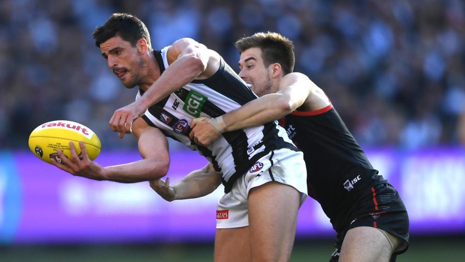 Zach Merrett tackles Collingwood's Scott Pendlebury