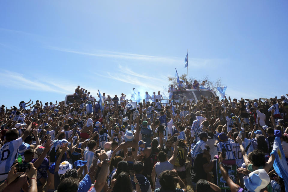 The Argentine soccer team that won the World Cup tournament rides on an open bus in a homecoming parade in Buenos Aires, Argentina, Tuesday, Dec. 20, 2022. (AP Photo/Natacha Pisarenko)