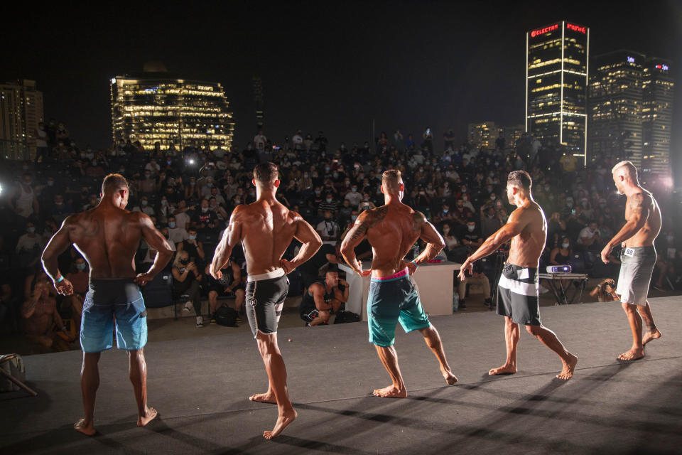 Contestants participate in the final round during the National Amateur Body Builders Association competition in Tel Aviv, Israel, Wednesday, Aug. 19, 2020. Because of the coronavirus pandemic, this year's competition was staged outdoors in Tel Aviv. The 85 participants were required to don protective masks in line with health codes. (AP Photo/Oded Balilty)