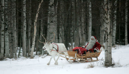 A man dressed as Santa Claus rides his sleigh as he prepares for Christmas on the Arctic Circle in Rovaniemi, northern Finland, December 19, 2007. REUTERS/KACPER PEMPEL/File Photo