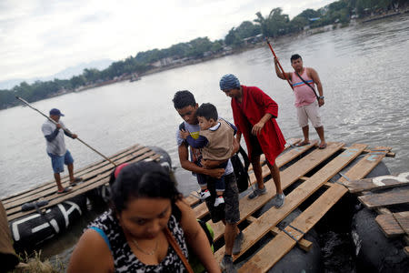 Honduran migrants, part of a caravan trying to reach the U.S., come down from a raft after crossing the Suchiate River on a raft to avoid the border checkpoint in Ciudad Hidalgo, Mexico, October 20, 2018. REUTERS/Edgard Garrido