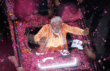 India's Prime Minister Narendra Modi waves towards his supporters during a roadshow in Varanasi, India, April 25, 2019. REUTERS/Adnan Abidi