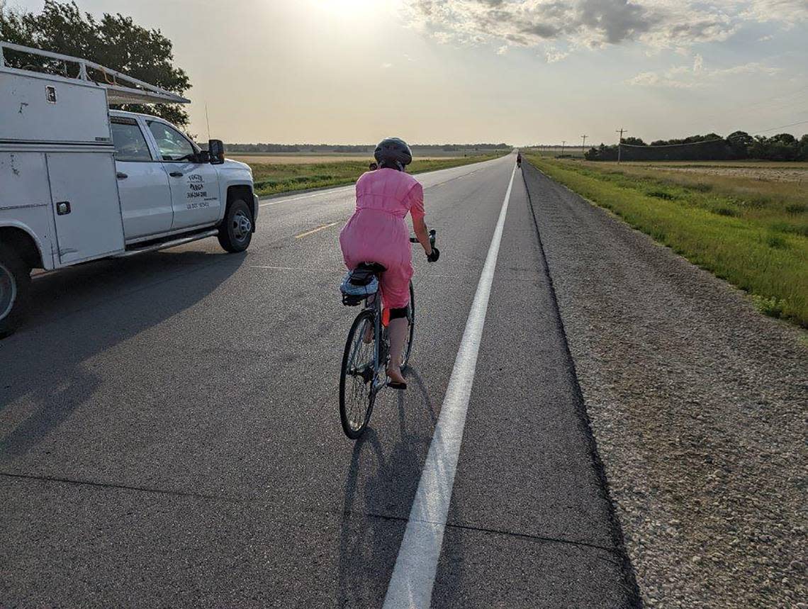 Cindy Miller rides along Hwy 150 between Marion and Elmdale, Kansas, in a pink dress and without shoes.