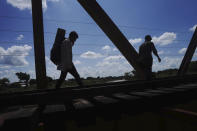 Migrants who are part of caravan cross a railroad track in Huixtla, Chiapas state, Mexico, Tuesday, Oct. 26, 2021, on a day of rest before continuing their trek across southern Mexico to the U.S. border. (AP Photo/Marco Ugarte)