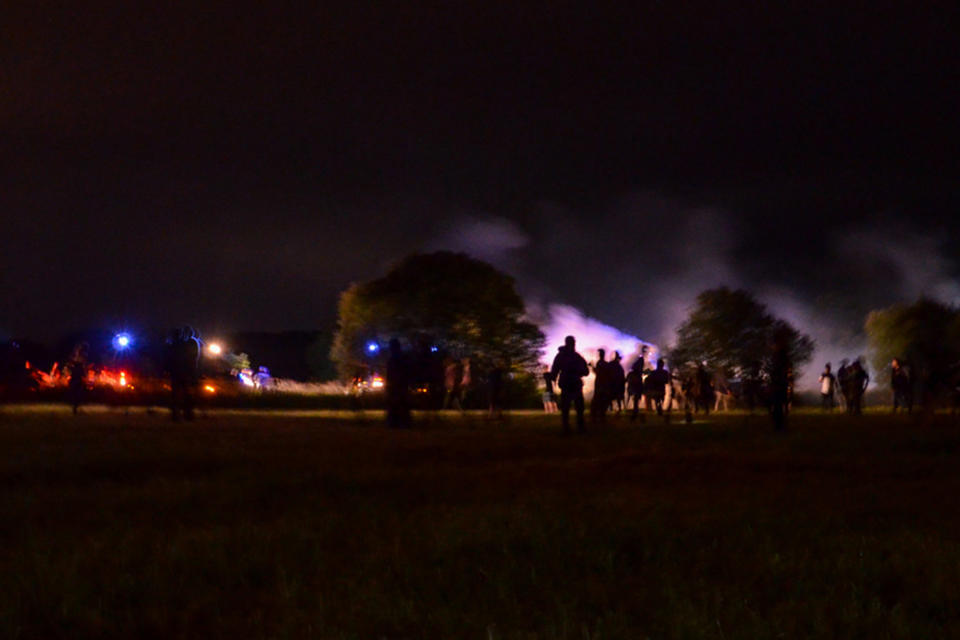 Youths stand in a field during clashes as police tried to break up an unauthorized rave party near Redon, Brittany, Friday June 18, 2021. Police repeatedly fired tear gas and charged clusters of violent partiers who hurled metal balls, gasoline bombs and other projectiles at security forces, according to images of the clashes shared online and the top government official in the region. Local authorities estimated about 1,500 people took part despite a local ordinance banning the event. (AP Photo)