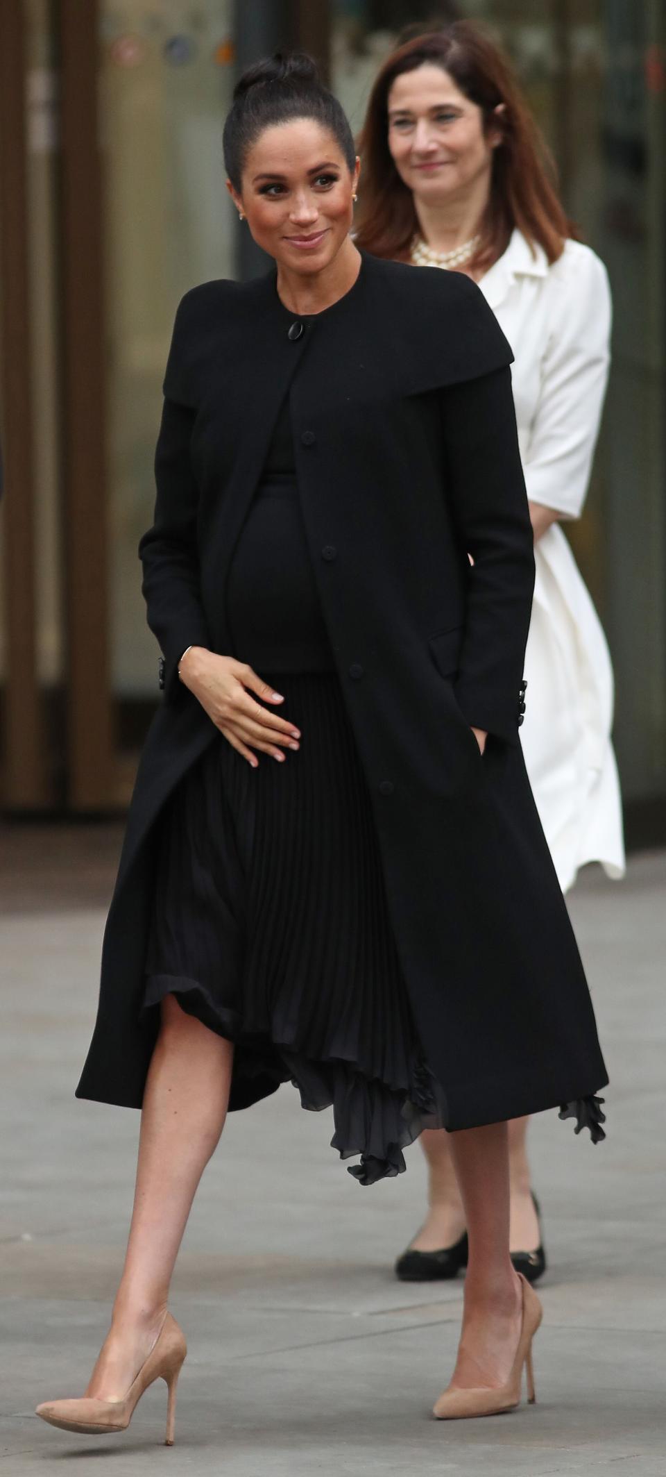 Meghan reacts as she leaves after meeting with students and academics from across the Association of Commonwealth Universities at City University in London.