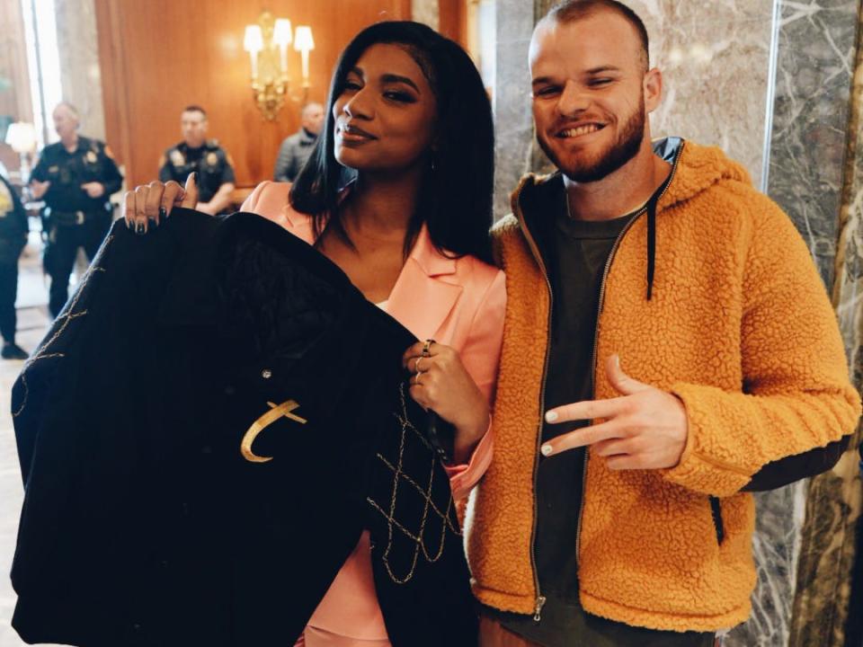 John Thomas and Taylor Rooks pose with one of his custom varsity jackets.