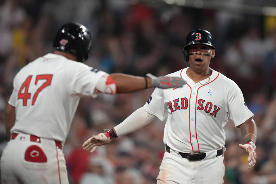 Boston Red Sox's Rafael Devers, right, celebrates with Enmanuel Valdez, left, as he returns to the dugout after scoring on a two-run triple by Connor Wong in the seventh inning of a baseball game against the New York Yankees, Sunday, June 16, 2024, in Boston. (AP Photo/Steven Senne)