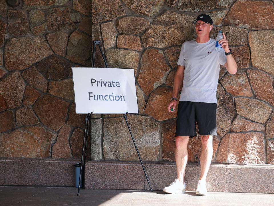 Hans Vestberg waves while holding water bottle next to "Private Function" sign