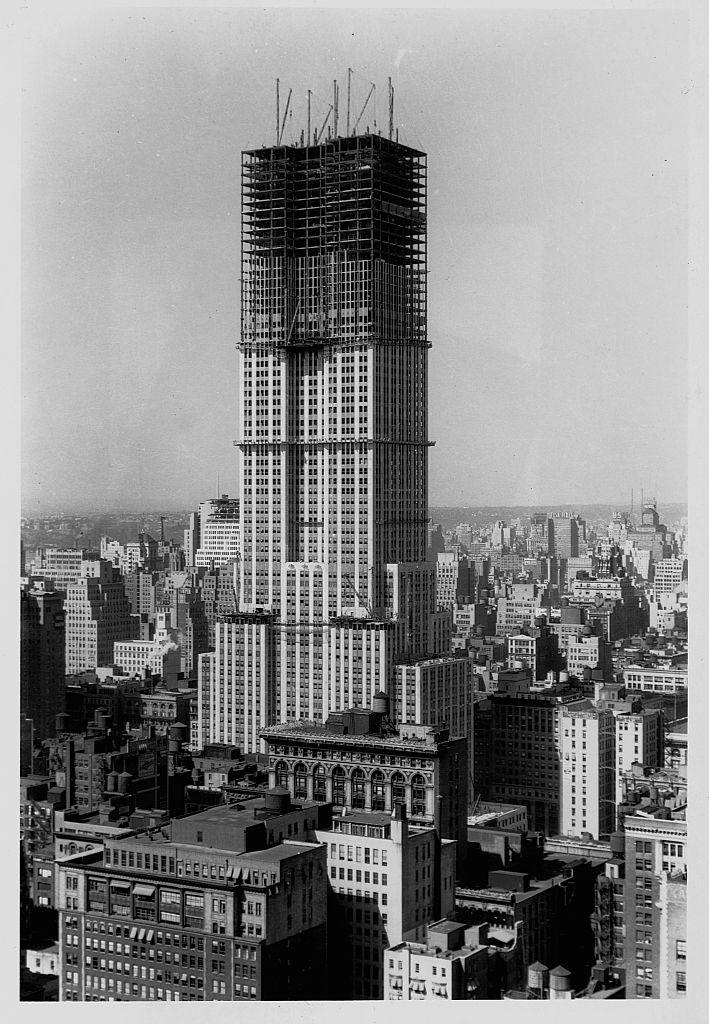 Black-and-white photo of the building with the top floors with scaffolding