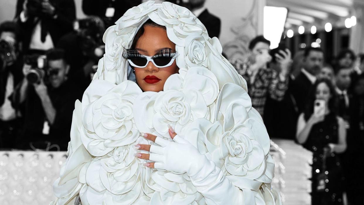 a person wearing a white dress and sunglasses with flowers