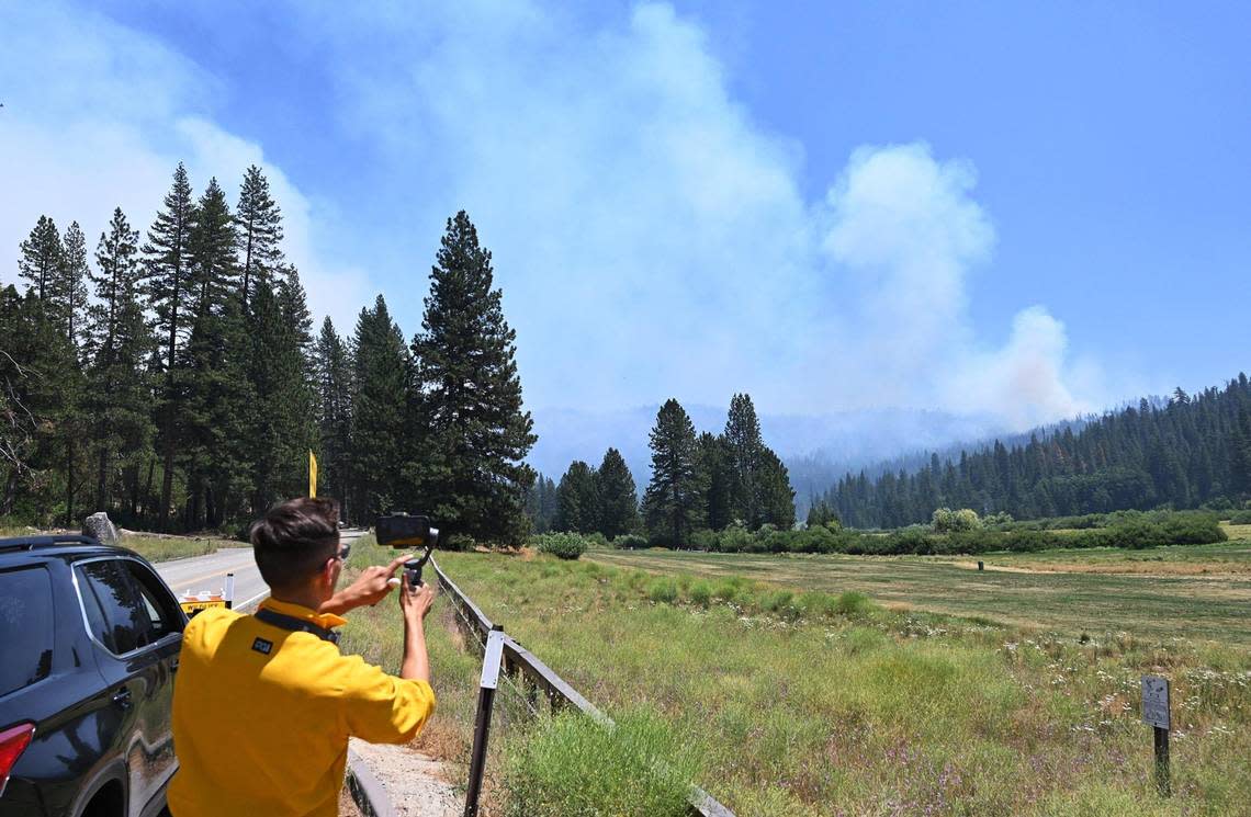 The Washburn Fire, seen in the distance from the roadside alongside the Wawona golf course, continues to burn in Yosemite National Park Monday, July 11, 2022.