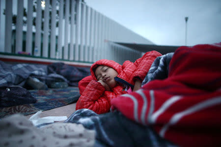 A child traveling with a caravan of migrants from Central America sleeps near the San Ysidro checkpoint after a small group of fellow migrants entered the United States border and customs facility, where they are expected to apply for asylum, in Tijuana, Mexico April 30, 2018. REUTERS/Edgard Garrido