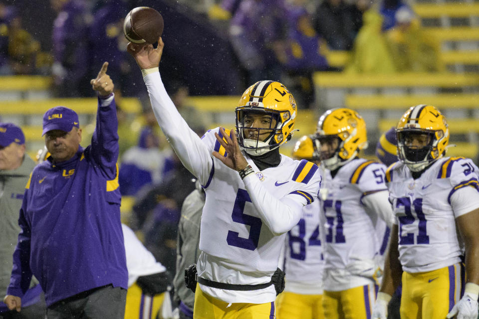 LSU quarterback Jayden Daniels (5) warms up in the rain before the team's NCAA college football game against UAB in Baton Rouge, La., Saturday, Nov. 19, 2022. (AP Photo/Matthew Hinton)