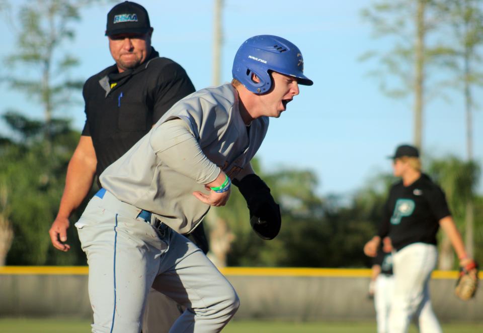 Fernandina Beach's Sean Benjamin shouts in celebration after sliding across the plate for a first-inning run against Providence in the 2023 district tournament.