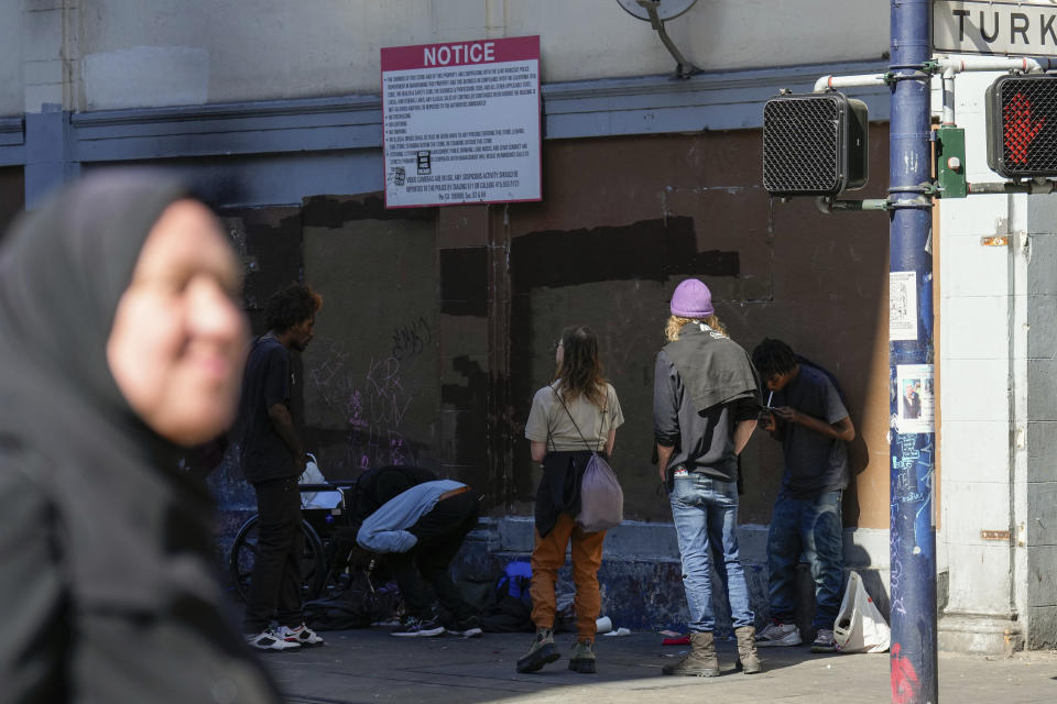 Tatiana Alabsi, foreground, walks in the Tenderloin neighborhood after work Saturday, April 20, 2024, in San Francisco. (AP Photo/Godofredo A. Vásquez)