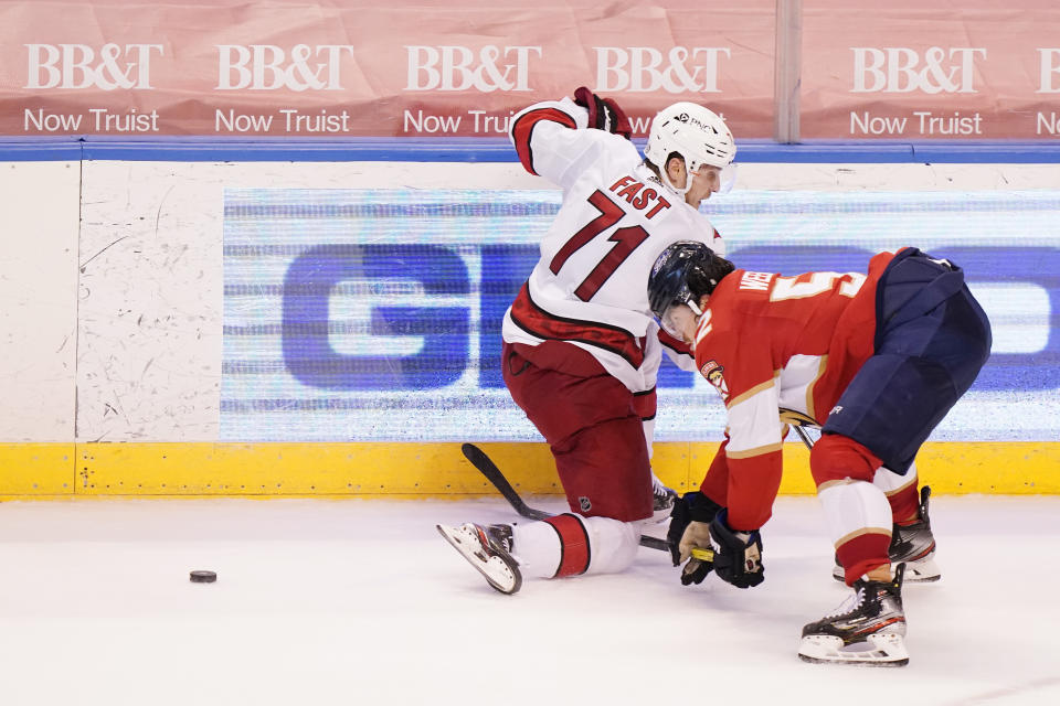 Carolina Hurricanes right wing Jesper Fast (71) and Florida Panthers defenseman MacKenzie Weegar (52) battle for the puck during the third period of an NHL hockey game, Monday, March 1, 2021, in Sunrise, Fla. (AP Photo/Wilfredo Lee)