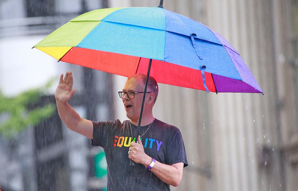 Grand Marshall of the 2015 Stonewall Columbus Pride Parade, Jim Obergefell waves to the soggy crowds on June 20, 2015.