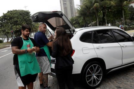 Stefan Weiss (L) and Alexander Costa sell food out of the trunk of a car in Rio de Janeiro, Brazil September 17, 2018.  REUTERS/Ricardo Moraes