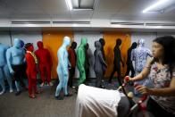 Participants wearing Zentai costumes, or skin-tight bodysuits from head to toe, walk in an underpass as they take part in a march down the shopping district of Orchard Road during Zentai Art Festival in Singapore May 23, 2015. Close to 50 participants strutted down the busy shopping district during the Zentai art festival which is jointly organized by the Japanese embassy. The festival includes performances and discussions on Zentai from May 22 to from June 5. REUTERS/Edgar Su