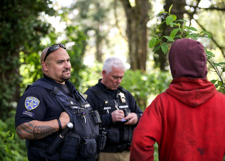 Officers Kevin Ramirez and Sean Bennett with Salem Police's Homeless Services Team connect people experiencing homelessness with available resources on Thursday, May 11, 2023 in Salem, Ore.