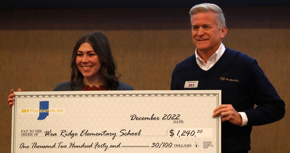 Ed Wulbrecht presents a grant to Wear Ridge Elementary School teacher Michela Rieck during a ceremony announcing recipients of the SIA Foundations grants, Tuesday, Dec. 13, 2022, at Subaru of Indiana Automotive in Lafayette, Ind. 