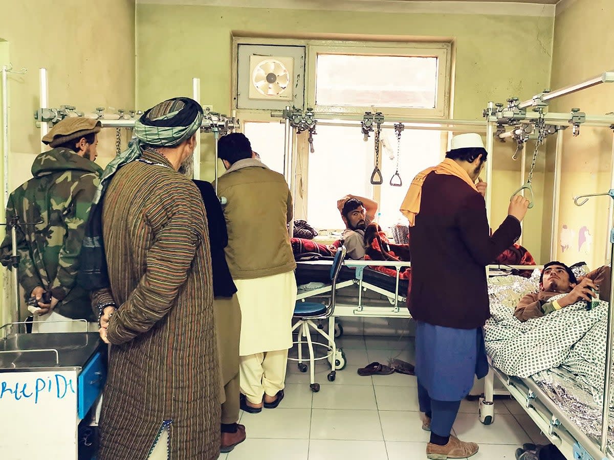 Wounded Afghan men receive treatment at a hospital following a blast at a madrassa in Aybak city of Samangan province on 30 November 2022 (AFP via Getty Images)