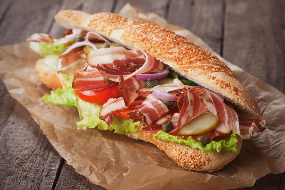 Submarine sandwich with bacon, pickles, tomato and lettuce salad