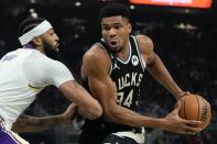 Milwaukee Bucks' Giannis Antetokounmpo drives past Los Angeles Lakers' Anthony Davis during the first half of an NBA basketball game Friday, Dec. 2, 2022, in Milwaukee. (AP Photo/Morry Gash)