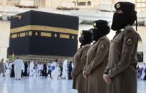 Saudi police women, who were recently deployed to the service, from right to left, Samar, Alaa, and Bashair, stand alert in front of the Kaaba, the cubic building at the Grand Mosque, during the annual hajj pilgrimage in the Saudi Arabia's holy city of Mecca, Tuesday, July 20, 2021. (AP Photo/Amr Nabil)