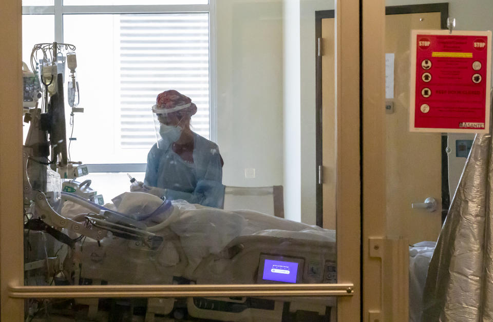 In this Thursday, Aug. 19, 2021, photo, a staff member treats a patient at the Critical Care Unit at Asante Three Rivers Medical Center in Grants Pass, Ore. The hospitalization rate of unvaccinated COVID-19 is breaking records and squeezing hospital capacity, with several running out of room to take more patients.(Mike Zacchino/KDRV via AP, Pool)