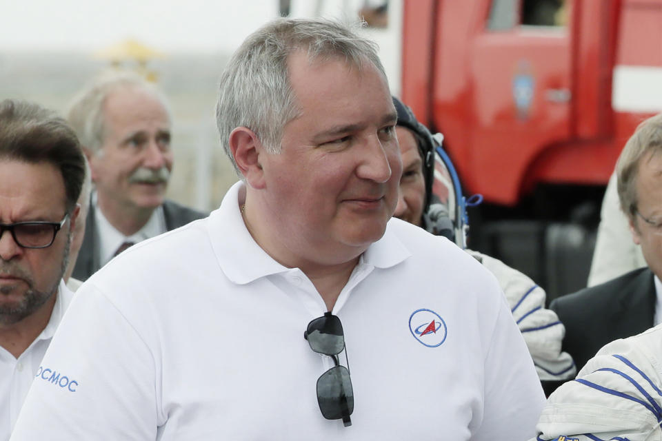 FILE - Roscosmos state space corporation head Dmitry Rogozin, accompanies new International Space Station crew members, to the rocket prior to the launch at the Russian leased Baikonur cosmodrome in Kazakhstan, on June 6, 2018. Russian President Vladimir Putin on Friday removed Dmitry Rogozin as the head of state-controlled Roscosmos space agency that oversees the country's space program and includes rocket factories, launch facilities and numerous other assets. (AP Photo/Dmitri Lovetsky, Pool Photo via AP, File)