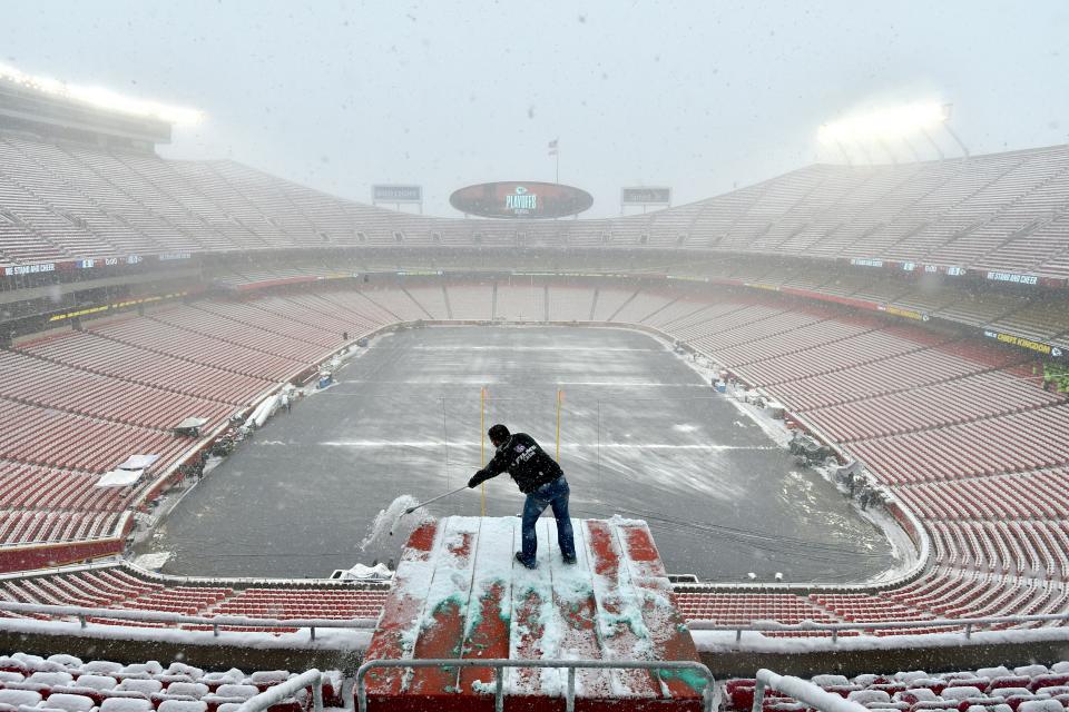 Kyle Haraugh, of NFL Films, clears snow from a camera location at Arrowhead Stadium before a Kansas City Chiefs NFL playoff game on Jan. 12, 2019.