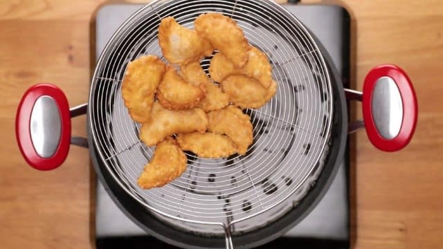 Freshly fried kok chye on a metal sieve