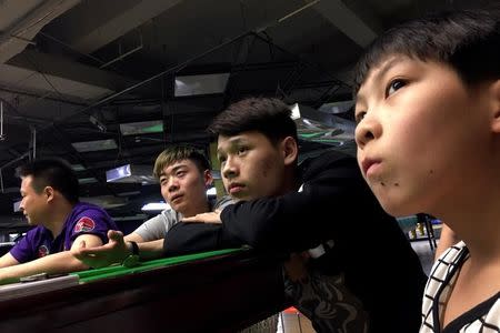 Students watch live Ding Junhui playing against Mark Selby on the television during the Betfred World Snooker Championship, at World Snooker College in Beijing, China, April 28, 2017. REUTERS/Thomas Suen