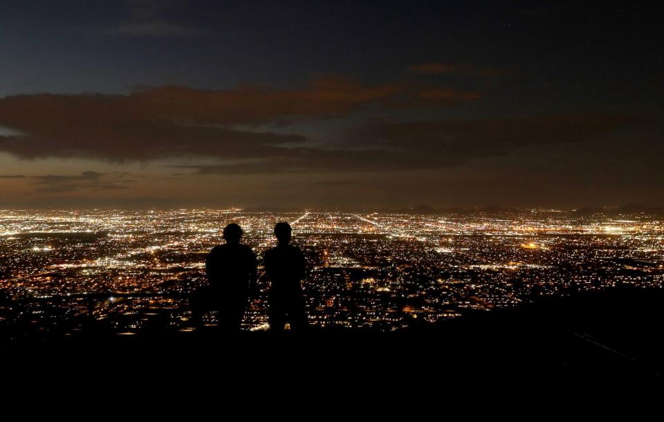 Visitors to Dobbins Lookout view the lights of Phoenix.