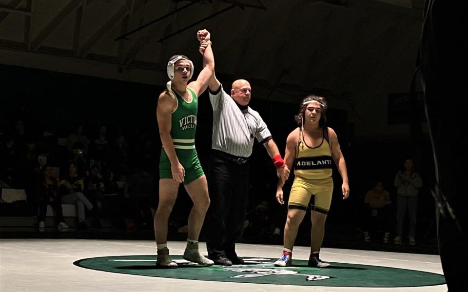 Victor Valley's David Camacho has his arm raised by the referee after scoring a pinfall victory Tuesday night.