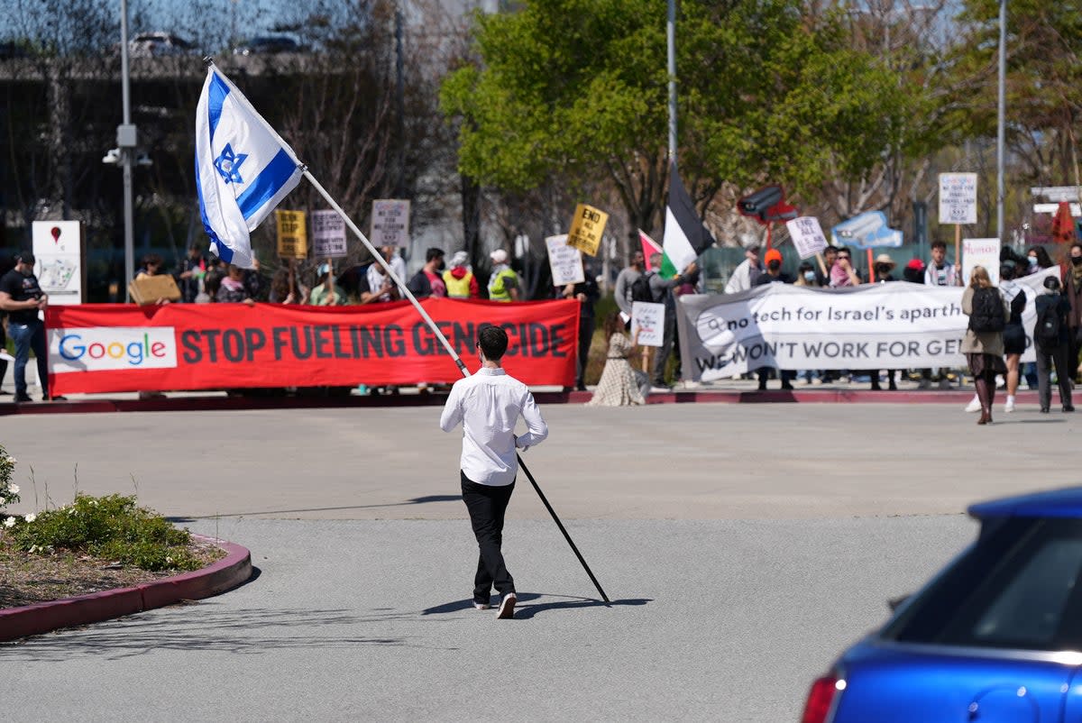 A counter-protester holding an Israeli flag walks into the parking lot near a protest at Google Cloud offices in Sunnyvale, California, US on April 16, 2024. (REUTERS/Nathan Frandino)