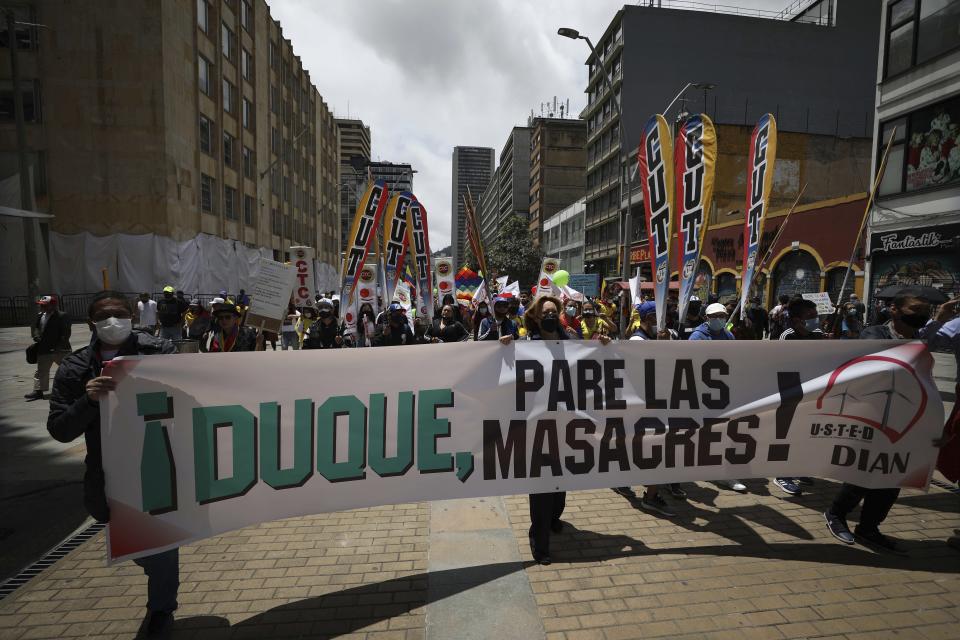 Manifestantes sostienen una pancarta con un mensaje dirigido al presidente de Colombia, Iván Duque, mientras marchan hacia la Plaza Bolívar en Bogotá, Colombia, el miércoles 12 de mayo de 2021. (AP Foto/Fernando Vergara)