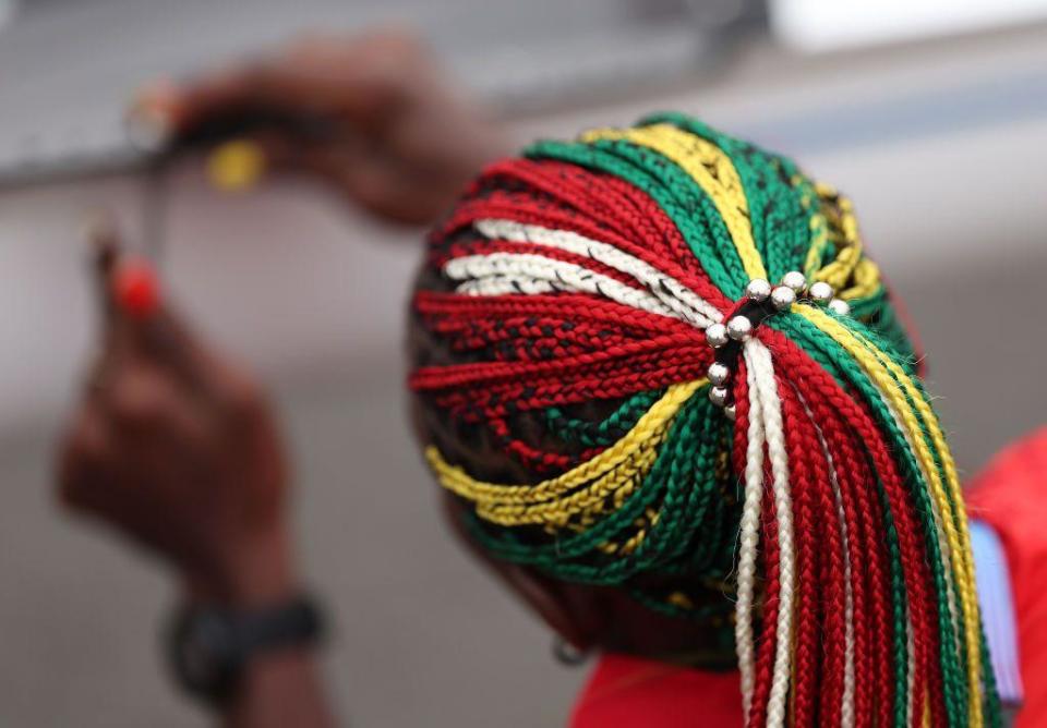 Togolese rower Akoko Komlanvi wears matching green braids and nails as she builds her boat before a rowing event at the Vaires-Sur-Marne Nautical Stadium - July 24, 2024 in Paris, France