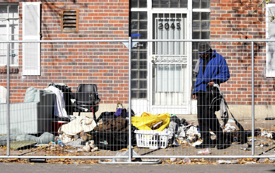 A homeless man sifts through his belongings during a sweep of an encampment in downtown Denver on Tuesday, Oct. 31, 2023. Crews erected fencing along several blocks near a post office, and police ordered campers to leave. More cities across the U.S. are cracking down on homeless tent encampments that have grown more visible and become unsafe. (AP Photo/Thomas Peipert)